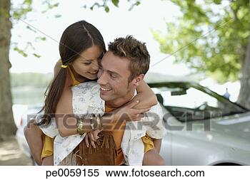 Stock Image - couple outdoors 
by convertible 
car embracing. 
fotosearch - search 
stock photos, 
pictures, images, 
and photo clipart