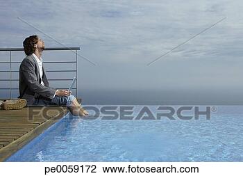Stock Photo - man sitting on 
deck with laptop 
by infinity pool. 
fotosearch - search 
stock photos, 
pictures, images, 
and photo clipart