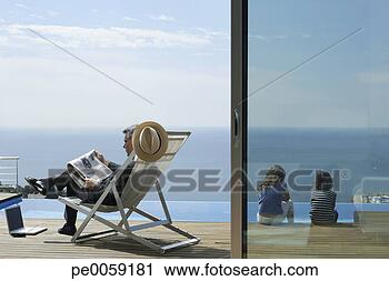 Stock Photography - man sitting outdoors 
reading with two 
kids sitting by 
pool. fotosearch 
- search stock 
photos, pictures, 
images, and photo 
clipart