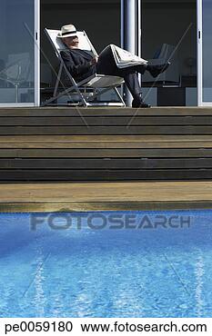 Stock Photography - man sleeping on 
deck by infinity 
pool. fotosearch 
- search stock 
photos, pictures, 
images, and photo 
clipart