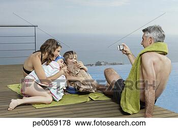 Stock Photo - man with woman 
and two kids on 
deck taking picture. 
fotosearch - search 
stock photos, 
pictures, images, 
and photo clipart