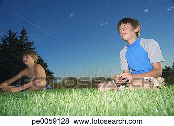Stock Photo - two boys sitting 
in grass field. 
fotosearch - search 
stock photos, 
pictures, images, 
and photo clipart