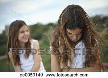 Stock Photograph - two girls outdoors 
with one happy 
and one upset. 
fotosearch - search 
stock photos, 
pictures, images, 
and photo clipart