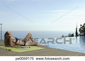 Stock Image - woman on deck 
by infinity pool. 
fotosearch - search 
stock photos, 
pictures, images, 
and photo clipart