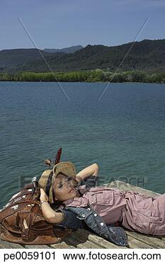 Stock Photography - woman lying on 
dock with large 
bag. fotosearch 
- search stock 
photos, pictures, 
images, and photo 
clipart