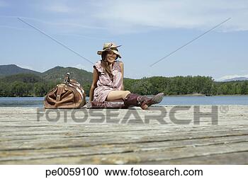 Stock Photography - woman sitting 
on dock with large 
bag. fotosearch 
- search stock 
photos, pictures, 
images, and photo 
clipart