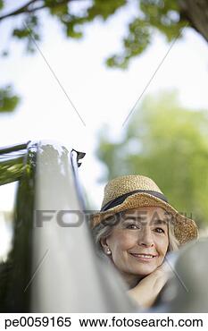 Stock Image - woman wearing 
hat smiling in 
a convertible 
car. fotosearch 
- search stock 
photos, pictures, 
images, and photo 
clipart