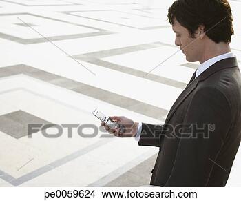 Stock Photo - businessman outdoors 
with his mobile 
phone. fotosearch 
- search stock 
photos, pictures, 
images, and photo 
clipart