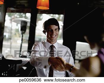 Stock Photo - man and woman 
in restaurant 
shaking hands. 
fotosearch - search 
stock photos, 
pictures, images, 
and photo clipart