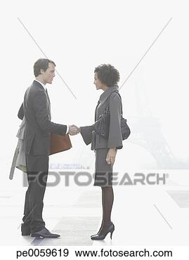 Stock Photograph - two businesspeople 
outdoor shaking 
hands by eiffel 
tower. fotosearch 
- search stock 
photos, pictures, 
images, and photo 
clipart