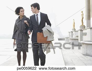 Stock Photo - two businesspeople 
outdoors walking 
by building near 
eiffel tower. 
fotosearch - search 
stock photos, 
pictures, images, 
and photo clipart
