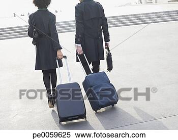 Stock Image - two businesspeople 
outdoors with 
luggage. fotosearch 
- search stock 
photos, pictures, 
images, and photo 
clipart