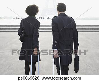 Stock Photo - two businesspeople 
outdoors with 
luggage by eiffel 
tower. fotosearch 
- search stock 
photos, pictures, 
images, and photo 
clipart