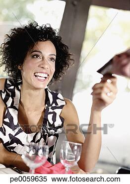 Stock Image - woman in restaurant 
handing credit 
card to waiter. 
fotosearch - search 
stock photos, 
pictures, images, 
and photo clipart