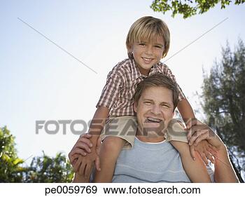 Stock Photograph - man giving young 
boy shoulder ride 
outdoors at park. 
fotosearch - search 
stock photos, 
pictures, images, 
and photo clipart