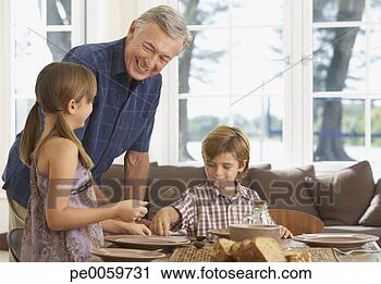 Stock Photography - man and two kids 
in dining room 
setting table. 
fotosearch - search 
stock photos, 
pictures, images, 
and photo clipart
