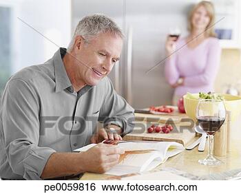 Stock Photo - couple in kitchen 
preparing meal 
with cook book. 
fotosearch - search 
stock photos, 
pictures, images, 
and photo clipart
