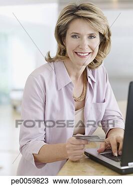 Banco de Imagem - mulher,  cozinha, 
 laptop,  crédito, 
 cartão. fotosearch 
- busca de fotos, 
imagens e clipart