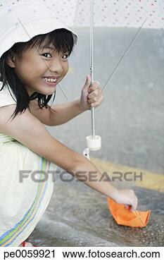 Arquivo de Fotografia - jovem,   menina, 
  ao ar livre, 
  chuva,   guarda-chuva, 
  tocando. fotosearch 
- busca de fotos, 
imagens e clipart