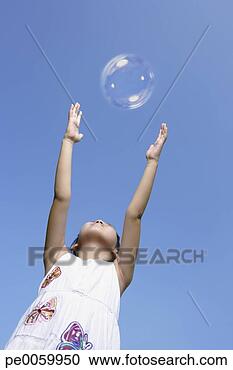 Stock Photography - young girl outdoors 
trying to touch 
a bubble. fotosearch 
- search stock 
photos, pictures, 
images, and photo 
clipart