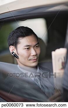 Stock Photo - businessman wearing 
earpiece in car 
with newspaper. 
fotosearch - search 
stock photos, 
pictures, images, 
and photo clipart