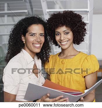 Arquivo de Fotografia - dois,  mulheres 
negócios,  escritório, 
 espaço,  segurando, 
 pasta. fotosearch 
- busca de fotos, 
imagens e clipart