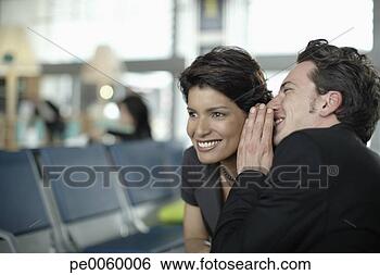 Stock Photo - man in airport 
whispering in 
woman's ear. fotosearch 
- search stock 
photos, pictures, 
images, and photo 
clipart