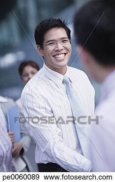 Stock Photograph - two businessmen 
outdoors shaking 
hands with co-workers 
in background. 
fotosearch - search 
stock photos, 
pictures, images, 
and photo clipart
