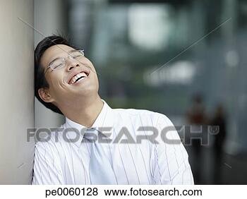 Stock Photo - businessman outdoors 
laughing leaning 
against large 
pillar. fotosearch 
- search stock 
photos, pictures, 
images, and photo 
clipart