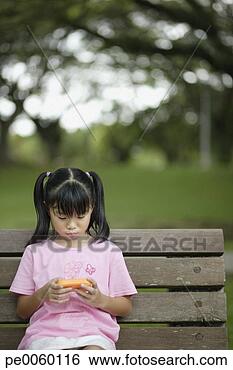 Banco de Imagem - jovem,  menina, 
 ao ar livre, 
 banco,  vídeo, 
 jogo. fotosearch 
- busca de fotos, 
imagens e clipart