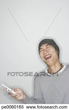 Stock Image - man indoors with 
mobile phone laughing. 
fotosearch - search 
stock photos, 
pictures, images, 
and photo clipart