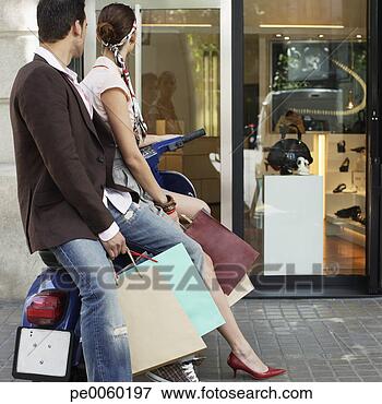 Picture - couple outdoors 
on scooter with 
shopping bags. 
fotosearch - search 
stock photos, 
pictures, images, 
and photo clipart