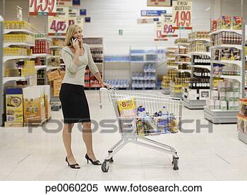 Stock Image - woman in grocery 
store on her mobile 
phone. fotosearch 
- search stock 
photos, pictures, 
images, and photo 
clipart