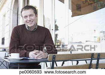 Stock Photo - businessman sitting 
with paperwork 
at outdoor patio 
table. fotosearch 
- search stock 
photos, pictures, 
images, and photo 
clipart