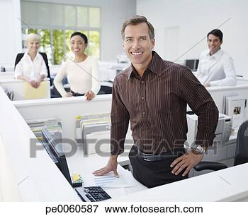 Picture - four businesspeople 
in an office looking 
at camera. fotosearch 
- search stock 
photos, pictures, 
images, and photo 
clipart