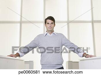 Arquivo de Fotografia - homem negócios, 
 ficar,  escritório, 
 entre,  cubículos. 
fotosearch - busca 
de fotos, imagens 
e clipart