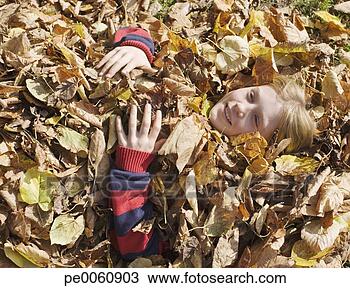 Banco de Imagem - jovem,  menina, 
 mentindo,  enterrado, 
 folhas,  ao ar 
livre. fotosearch 
- busca de fotos, 
imagens e clipart