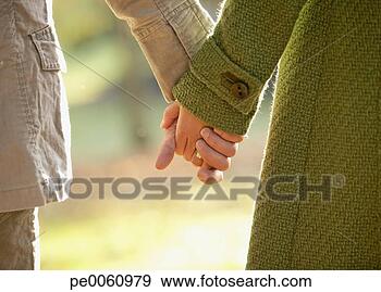Arquivo Fotográficos - par,  segurando, 
 mãos,  ao ar 
livre. fotosearch 
- busca de fotos, 
imagens e clipart