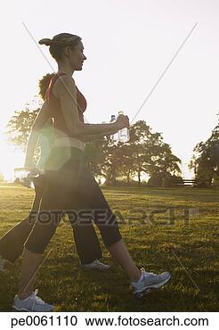 Arquivo de Fotografias - dois,   mulheres, 
  andar,   ao 
ar livre,   parque, 
  segurando. fotosearch 
- busca de fotos, 
imagens e clipart