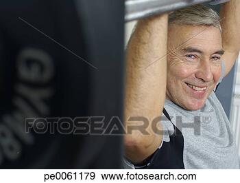 Stock Photograph - man in gym lifting 
weights. fotosearch 
- search stock 
photos, pictures, 
images, and photo 
clipart