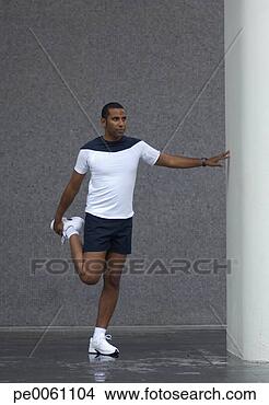Stock Photo - man stretching 
outdoors by a 
pillar. fotosearch 
- search stock 
photos, pictures, 
images, and photo 
clipart