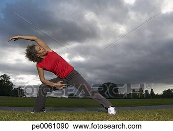 Arquivo de Fotografias - mulher,  esticar, 
 ao ar livre, 
 parque. fotosearch 
- busca de fotos, 
imagens e clipart