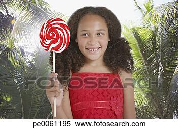 Banco de Imagem - jovem,  menina, 
 ao ar livre, 
 segurando,  pirulito. 
fotosearch - busca 
de fotos, imagens 
e clipart