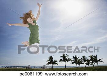 Arquivo Fotográficos - jovem,  menina, 
 ao ar livre, 
 praia,  pular. 
fotosearch - busca 
de fotos, imagens 
e clipart