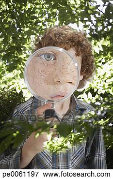 Foto - jovem,  menino, 
 ao ar livre, 
 olhar,  através, 
 magnificar,  
vidro. fotosearch 
- busca de fotos, 
imagens e clipart
