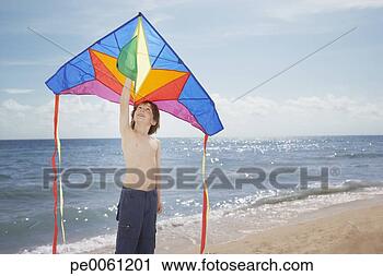 Arquivo de Fotografia - jovem,  menino, 
 praia,  segurando, 
 papagaio. fotosearch 
- busca de fotos, 
imagens e clipart