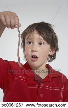 Picture - young boy indoors 
holding up an 
earthworm. fotosearch 
- search stock 
photos, pictures, 
images, and photo 
clipart