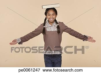 Picture - young girl balancing 
book on head indoors. 
fotosearch - search 
stock photos, 
pictures, images, 
and photo clipart