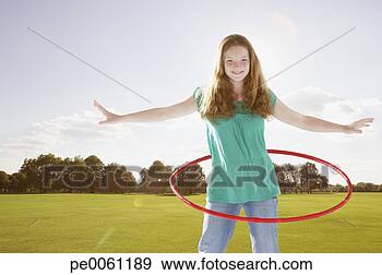 Stock Photograph - young girl outdoors 
using hula hoop 
at a park. fotosearch 
- search stock 
photos, pictures, 
images, and photo 
clipart