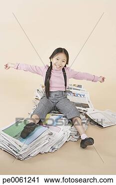 Stock Photography - young girl sitting 
on pile of newspapers 
indoors. fotosearch 
- search stock 
photos, pictures, 
images, and photo 
clipart